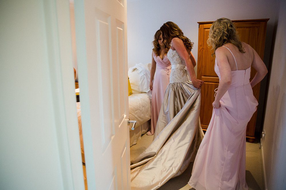 bride getting into wedding dress